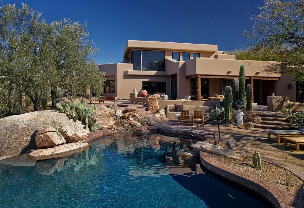 Modern house with a pool surrounded by desert cacti