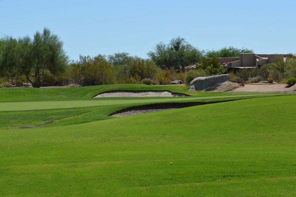 Golf course with bunkers under a clear sky