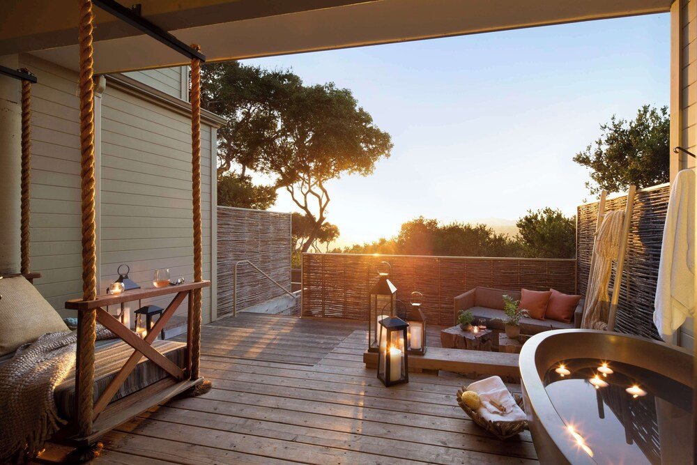 Wooden deck with a swing and a seating area
