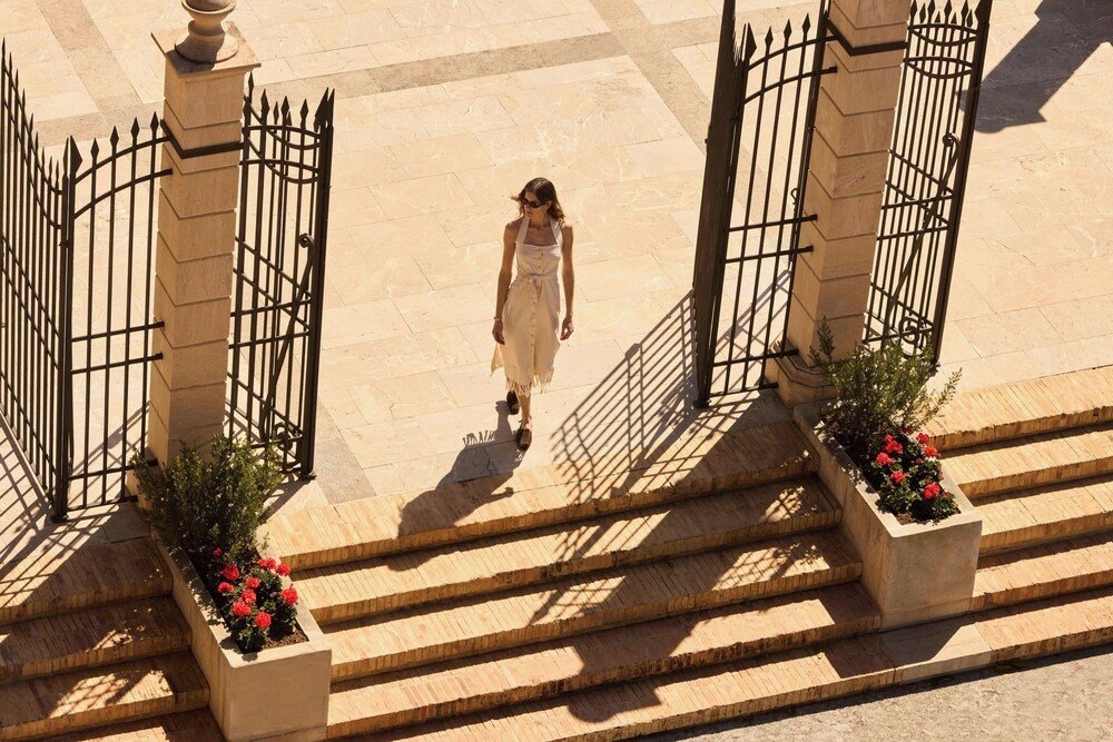 Mujer caminando por un sendero de los jardines