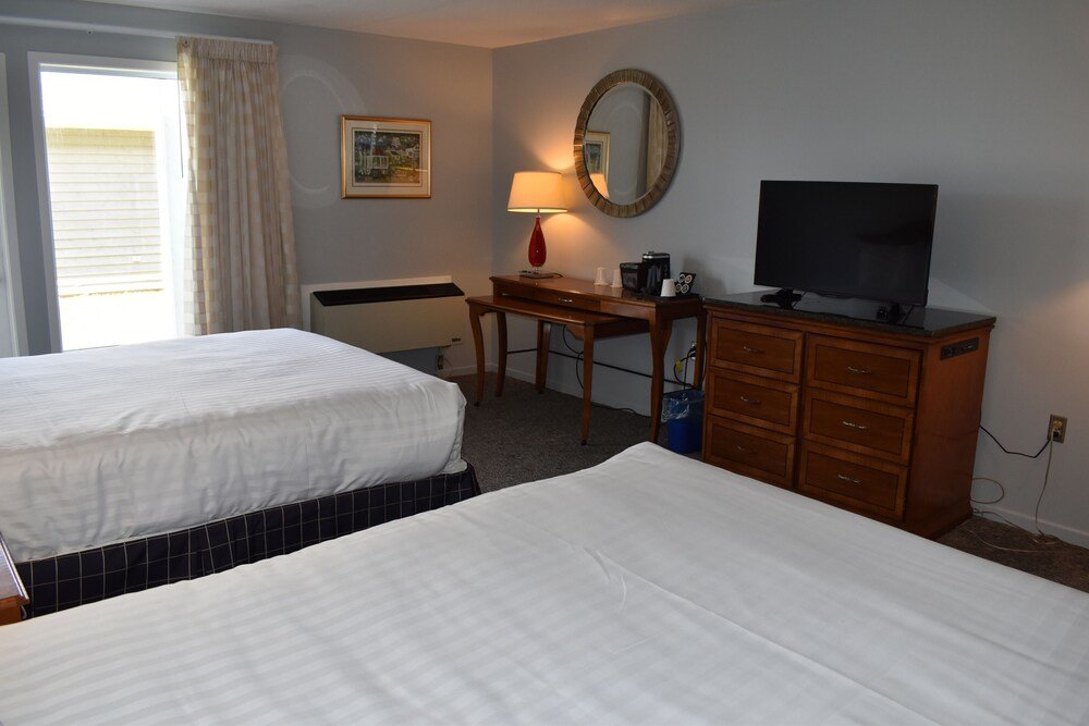 Room with two beds and a desk with a lamp