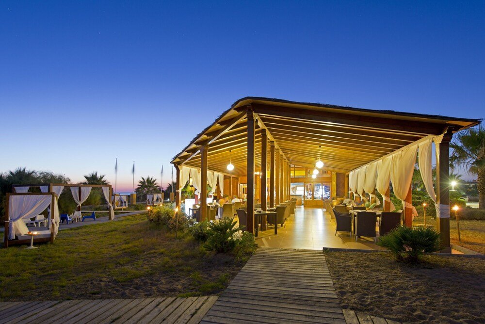 Comedor exterior cubierto del resort frente al mar en Rota