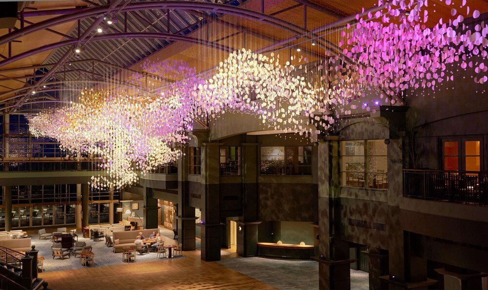 Spacious lobby with a high ceiling, large windows and seating