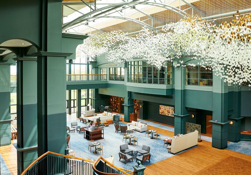 Lobby with seating areas, a staircase and a high ceiling