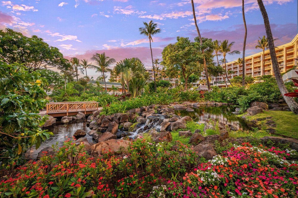 Resort pond with a wooden bridge and lush greenery