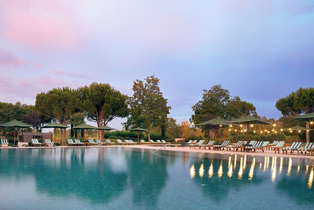 Piscina con reposeras en el Hotel Camiral, PGA Catalunya Resort
