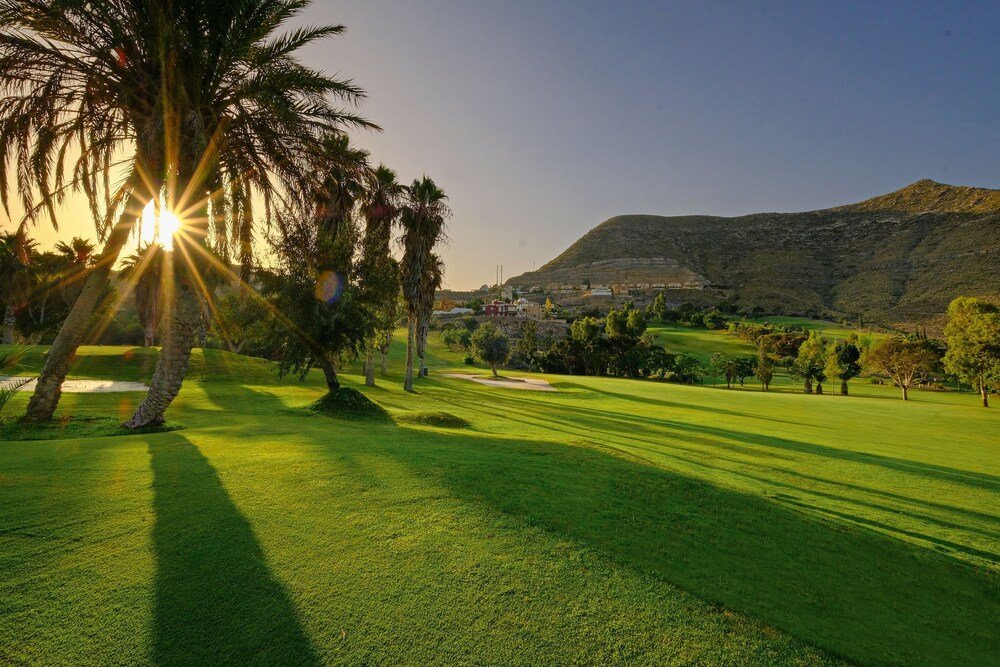 Golf course with mountains in the background near the hotel