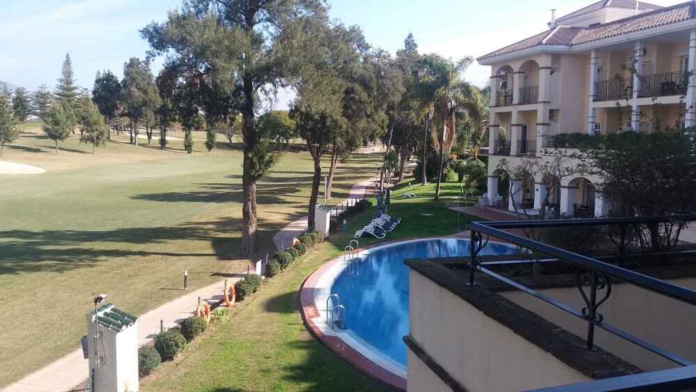 Pool area with a view over the golf course at the hotel
