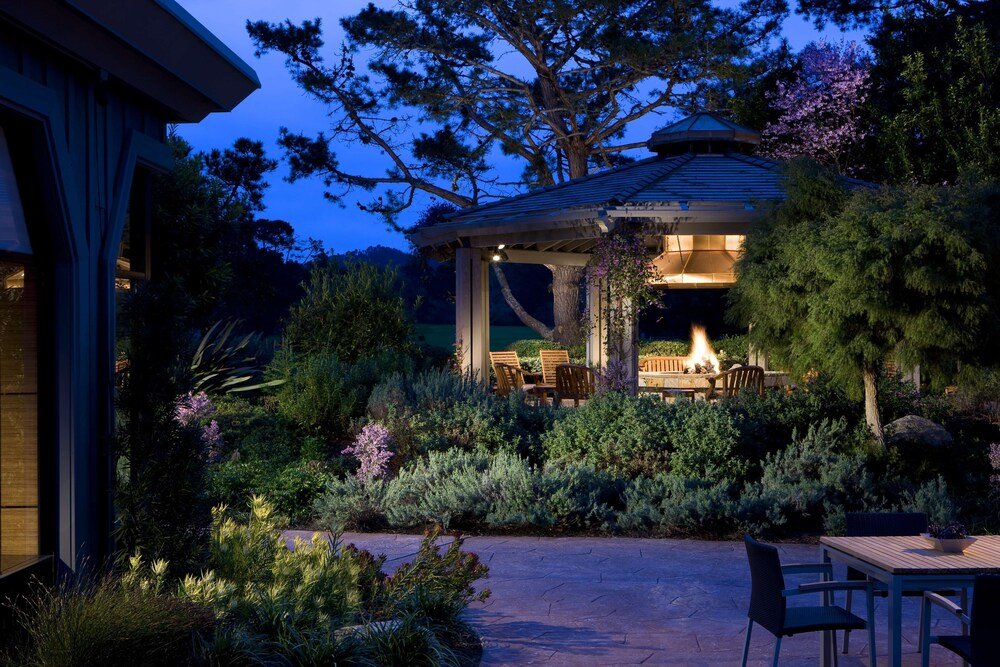 Gazebo with a fire surrounded by lush greenery