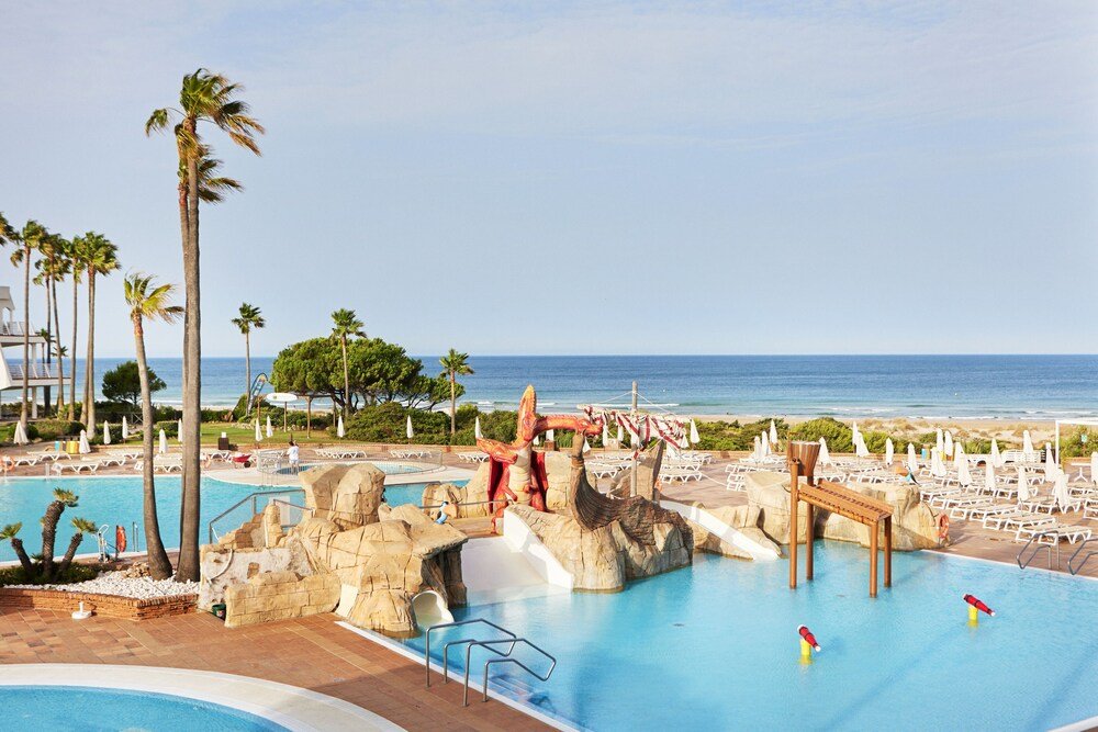 Resort pool with a water slide at Iberostar Waves Royal Andalus