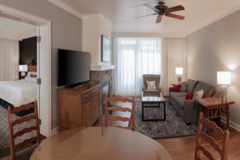Habitación con cama, televisor y sofá en el resort