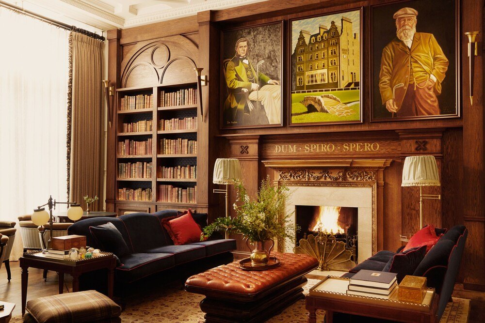 Biblioteca tradicional del hotel con estantes, chimenea y muebles clásicos