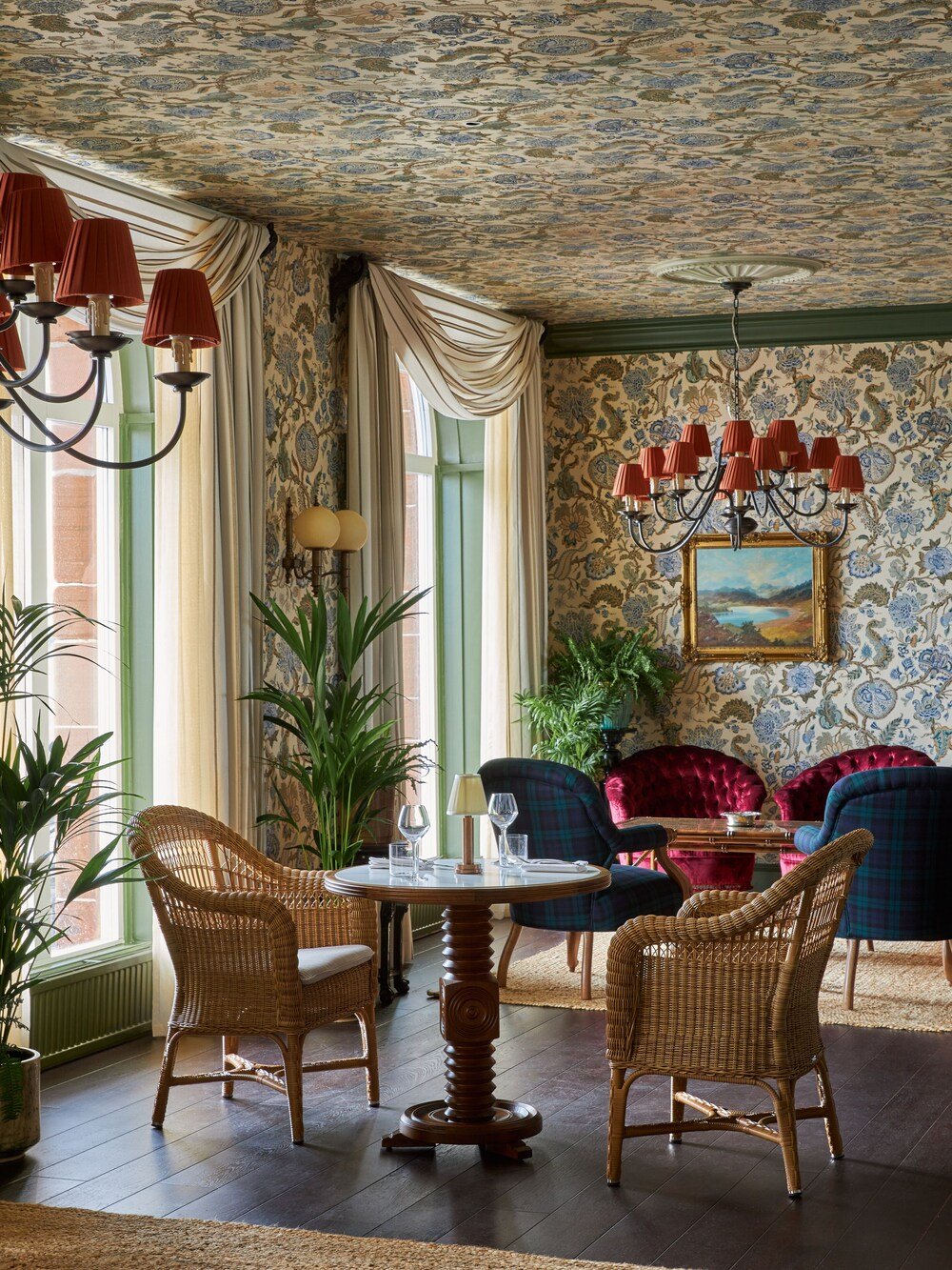 Dining area with wicker chairs, a round table and chandelier