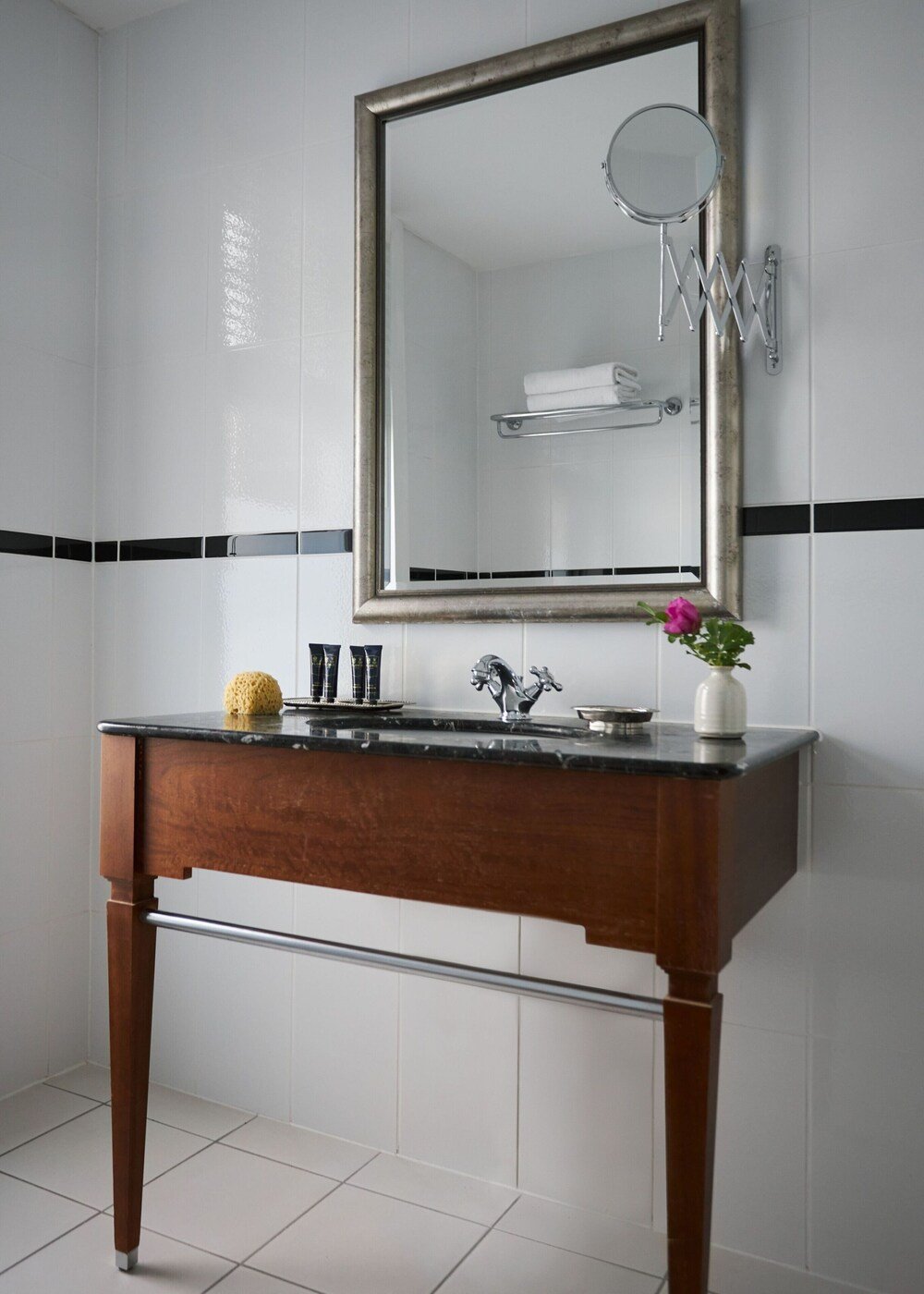 Bathroom with a wooden vanity and round mirror