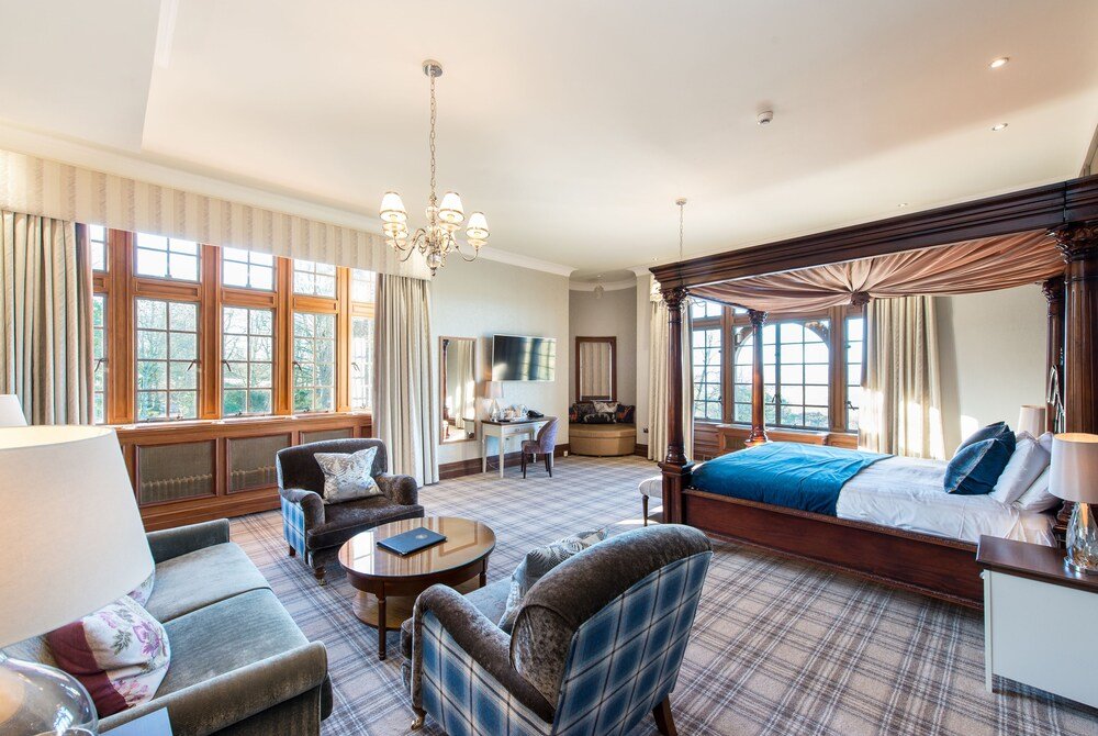 Spacious hotel room with a large bed and a sofa seating area