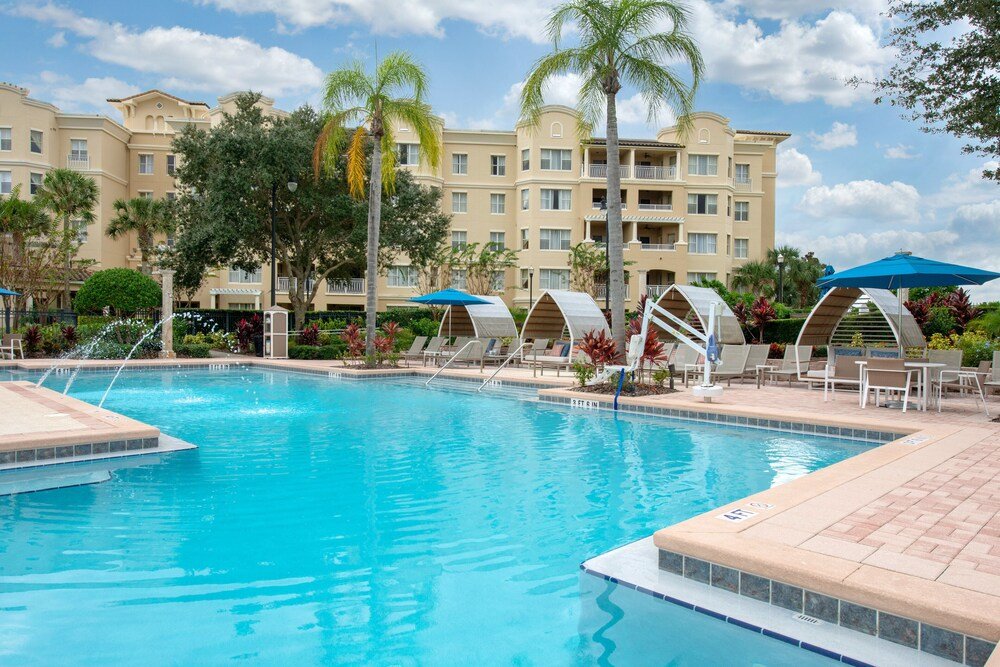 Resort swimming pool surrounded by lounge chairs and umbrellas