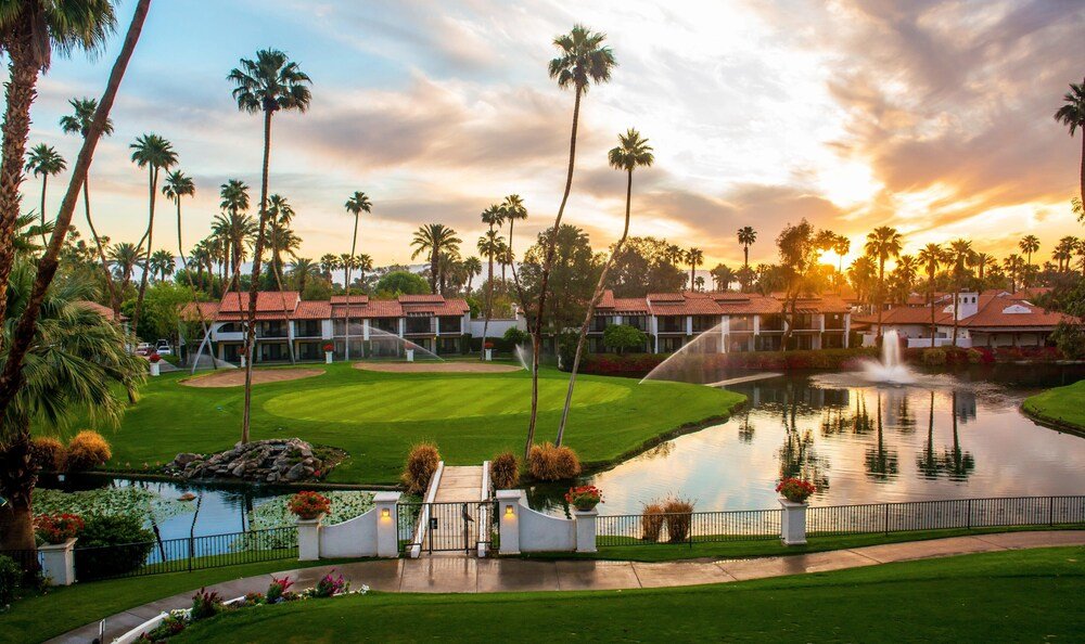 Resort with a pool, palm trees and a sunset