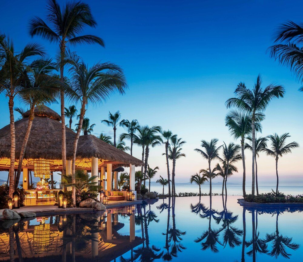 Resort grounds with a swimming pool and several palm trees