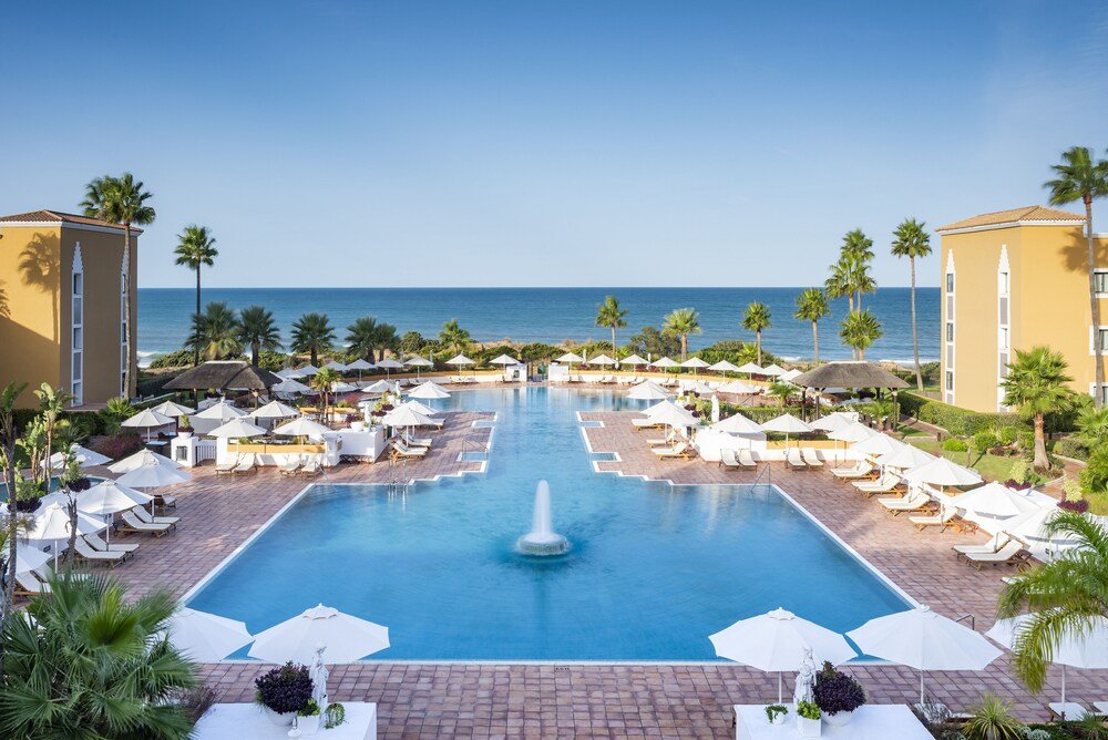 Piscina del resort con reposeras en Palacio de Sancti Petri