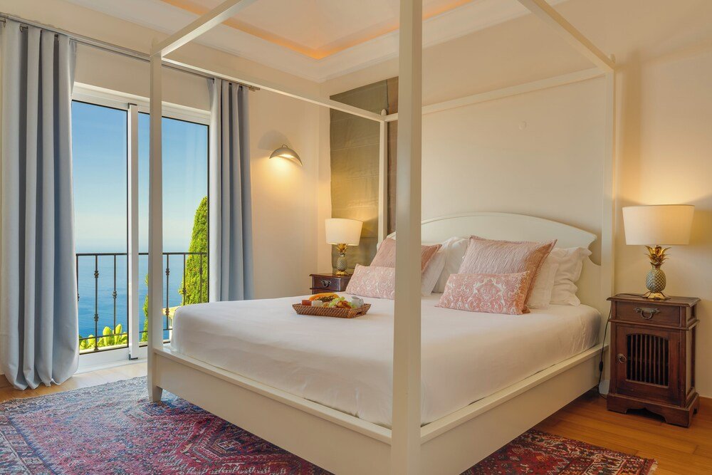 Bedroom with a four-poster bed at Palheiro Village in Funchal, Madeira