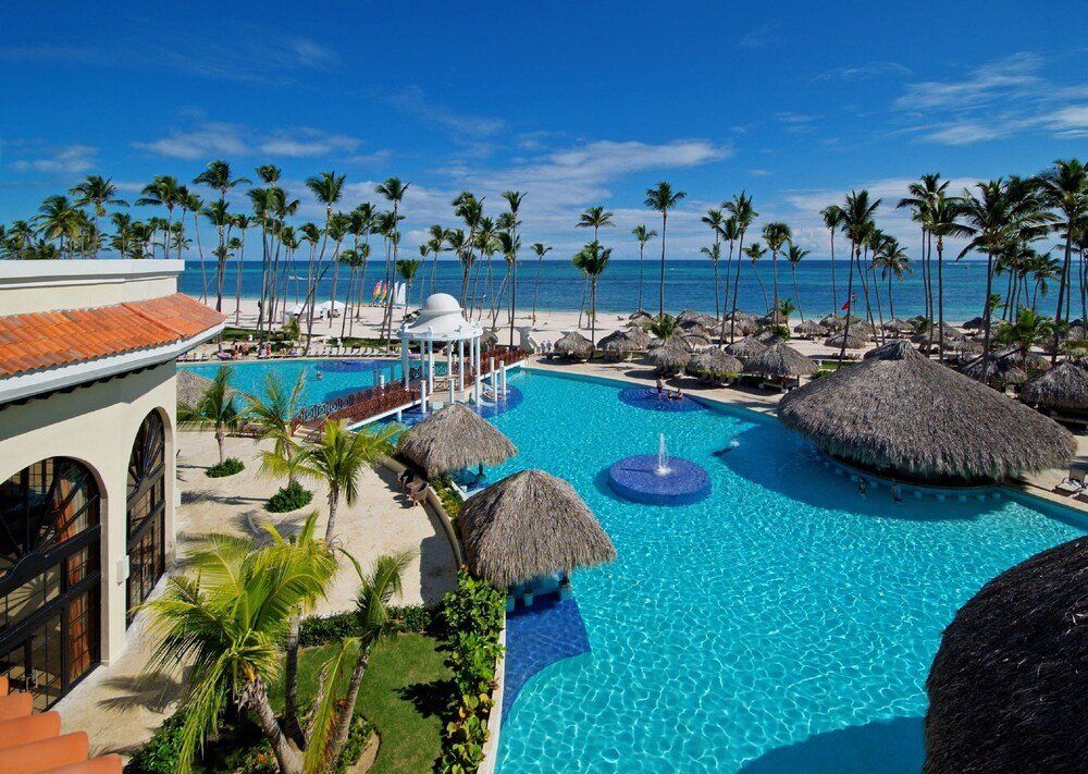 Resort pool with loungers and palm trees at Paradisus Palma Real in Bávaro, Punta