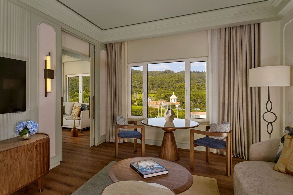 Habitación del hotel con un gran ventanal en Penha Longa Resort, cerca de Sintra,