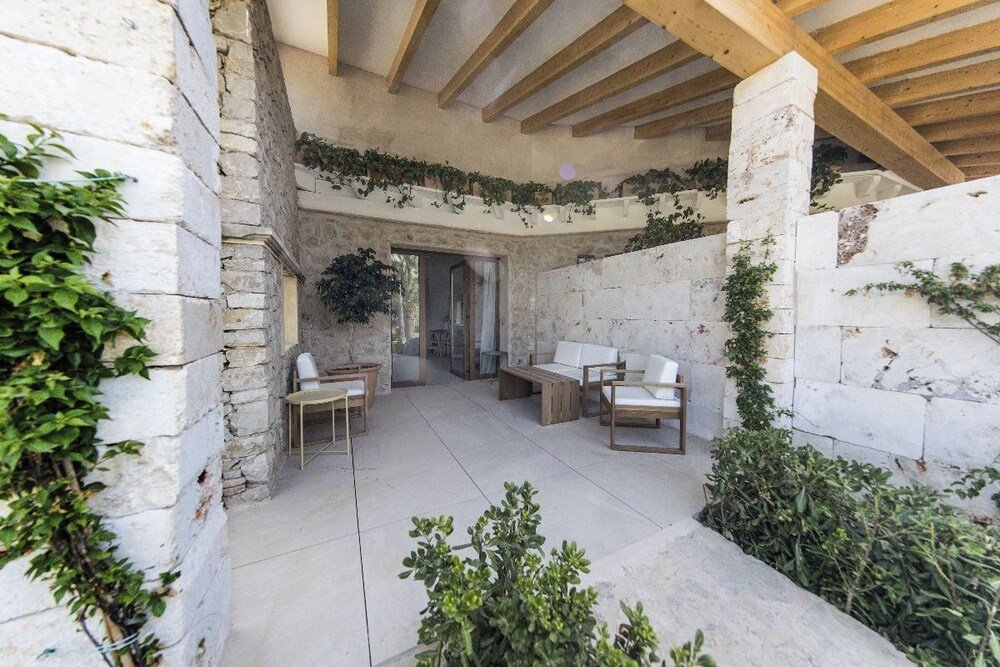 Covered patio area with seating at Pula Golf Resort in Son Servera, Mallorca