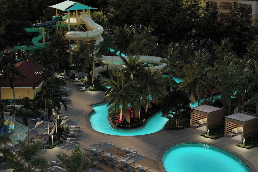 Resort pool area with water slide and lounge chairs