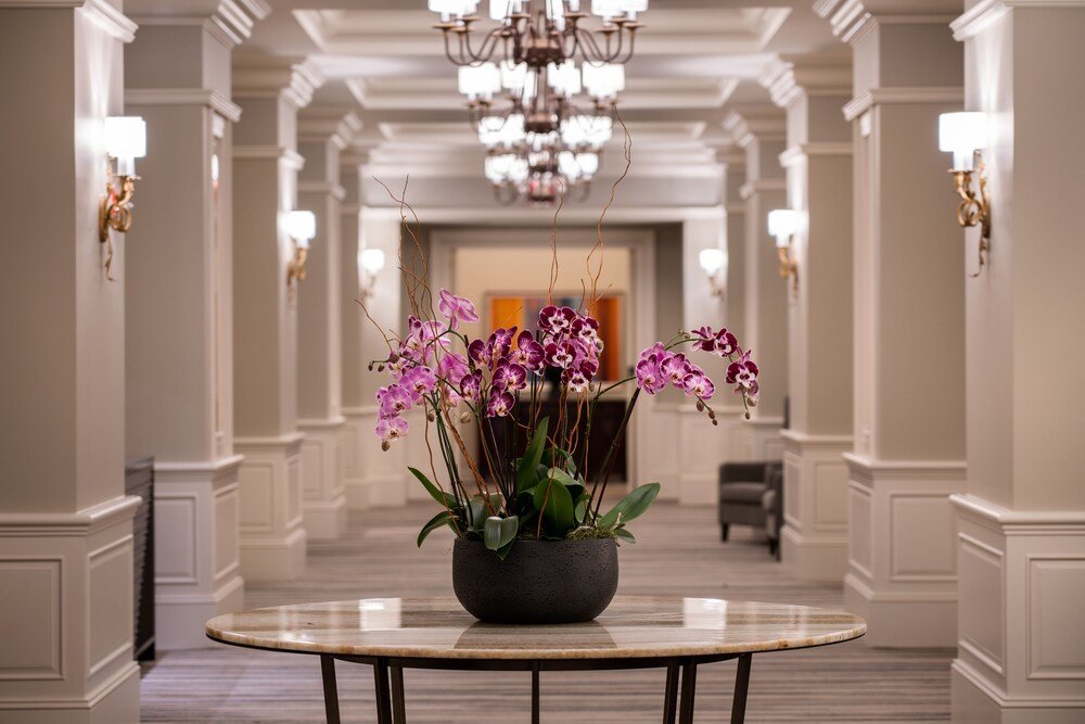 Hallway with a round table and chandelier
