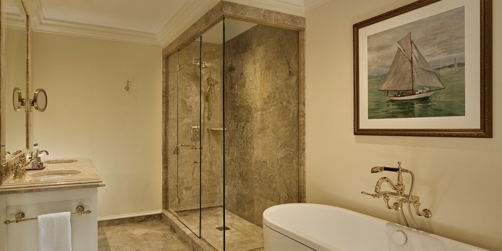 Bathroom with glass shower and classic bathtub at Trump Turnberry