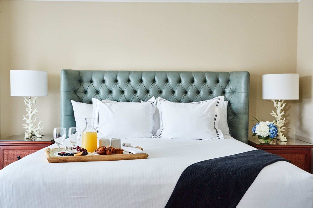 Neatly made bed with a tufted headboard at Wild Dunes Resort
